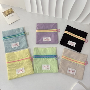 Flat lay of colorful nylon mini pouches in blue, purple, black, yellow, green and beige