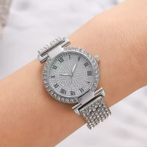 Montre de luxe argentée pour femme avec cadran plein strass et chiffres romains sur métal
