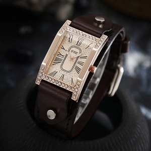 Macro view of crystal-encrusted rectangular rose gold watch case with brown leather strap