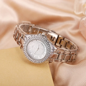 Gros plan détaillé d'une montre à quartz argentée ornée de strass sur satin couleur champagne