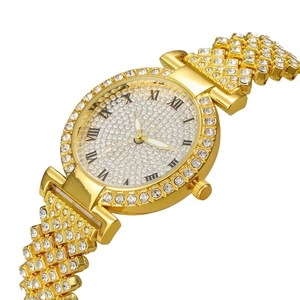 Détail macro d'une montre de luxe dorée avec chiffres romains et pavé de cristaux brillants