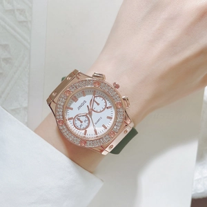 Détail d'une montre à lunette diamants en or rose avec bracelet en silicone vert foncé