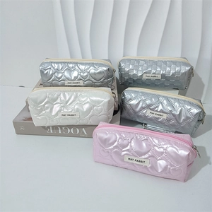 Pochette cosmetiche trapuntate in argento, rosa e bianco con motivi a cuore