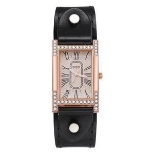 Detail of rose gold H-shaped crystal case and black leather strap with silver rivets