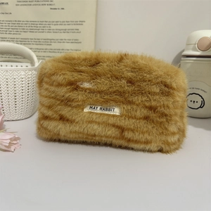 Close-up of soft leopard plush cosmetic bag featuring a rectangular brand logo tag