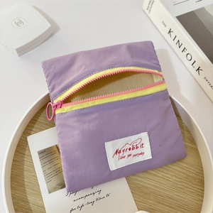 Detail of purple nylon storage pouch with contrasting pink zipper and branded woven label