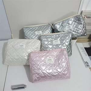 Close-up of quilted heart patterns on portable PU leather makeup bags in multiple colors