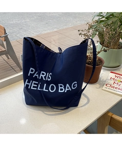 Close-up of navy canvas tote bag with white lettering and red plaid fabric lining