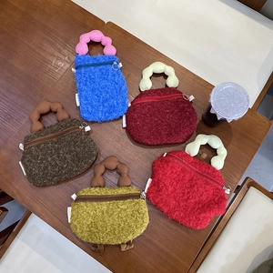 Detailed overhead shot of colorful plush handbags with bubble handles on wooden table