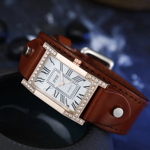 Detail of rose gold rectangular watch with rhinestone bezel and brown rivet leather strap