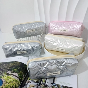 Dettaglio della borsa trapuntata in PU metallizzato con texture argento e rosa e cuori