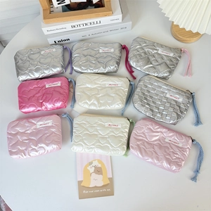 Macro shot of quilted heart pattern mini purses in multiple pastel colors with zipper detail