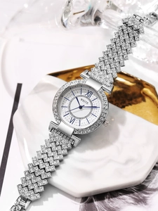 Détail de montre argentée de luxe avec lunette en cristal et aiguilles bleues