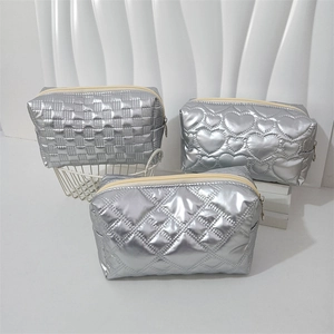 Close-up of three silver waterproof PU vanity bags with heart and grid quilted patterns