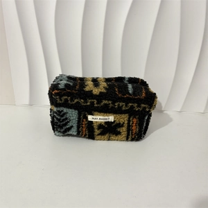 Detail of plush fleece cosmetic bag with geometric ethnic pattern and secure zipper