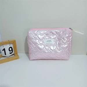 Detail of pink heart quilted makeup bag with pearlescent finish and silver zipper