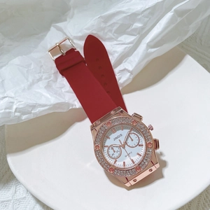 Détail macro de la montre Jingis or rose avec diamants et bracelet en silicone rouge