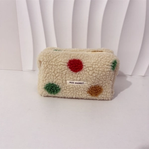 Close-up of the soft plush material and colorful polka dots on the makeup bag