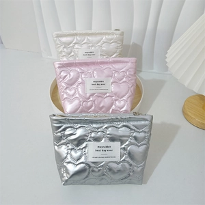 Macro detail of heart quilted PU leather makeup pouches with metallic and satin finishes