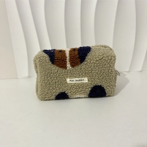 Close-up of plush fleece makeup bag featuring blue and brown contrast patterns and zipper