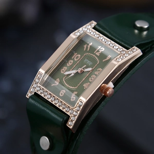 Macro detail of a rose gold square watch with green sunray dial and diamond bezel