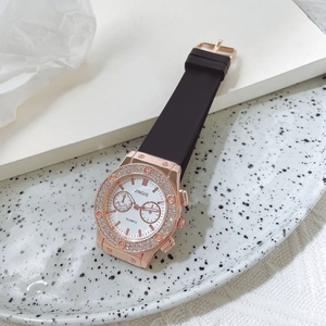 Détail d'une montre à quartz or rose avec lunette diamantée et bracelet silicone