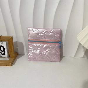 Detail of pink heart-quilted PU jewelry pouch with blue contrast zipper and round pull