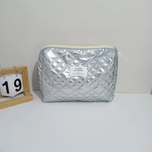 Macro view of silver quilted PU cosmetic bag showing diamond stitching and metal zipper