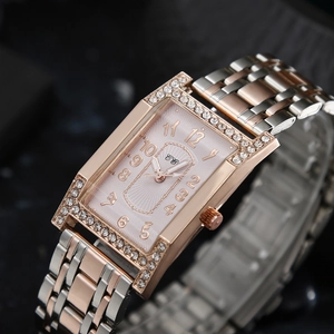 Detail of rose gold rectangular watch featuring diamond bezel and sunray dial design