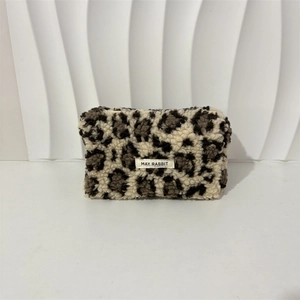Close-up of plush leopard print makeup bag featuring a May Rabbit label and soft texture