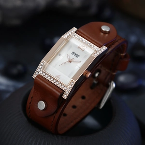 Detail of vintage square quartz watch with brown leather rivet strap and diamond bezel
