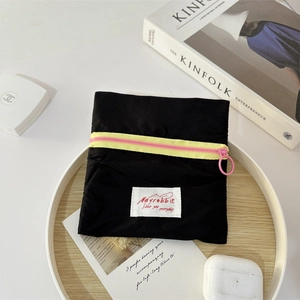 Macro view of canvas mini pouch with contrast yellow zipper and pink pull on wooden tray