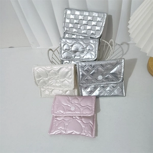 Close-up of quilted PU coin purses in heart and grid patterns with snap buttons