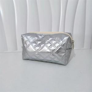 Detail of silver quilted waterproof PU makeup bag with durable zipper and metal ring pull