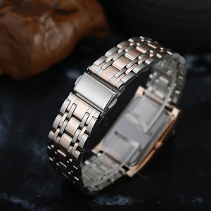 Detail of silver and rose gold steel watch band with folding clasp on marble