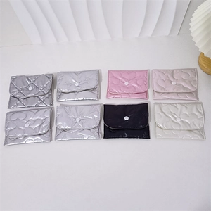 Flat lay of eight colorful quilted PU leather pouches with heart and bow patterns