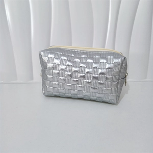 Detailed close-up of a silver quilted makeup bag with a metallic finish and zipper