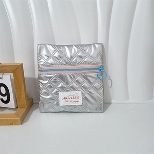 Close-up of metallic silver quilted pouch with pink zipper and light blue circular puller
