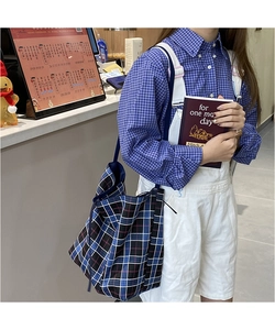 Detail of blue and white plaid tote bag with large capacity and durable canvas straps