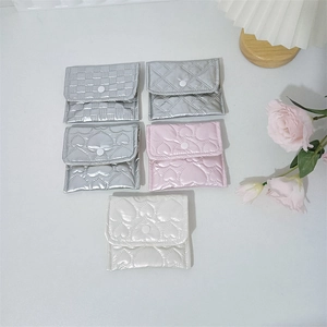 Flat lay of quilted PU leather mini storage pouches in silver, pink, and white tones