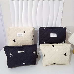 Quilted makeup bags with rabbit embroidery and ribbon bow in black and beige colors
