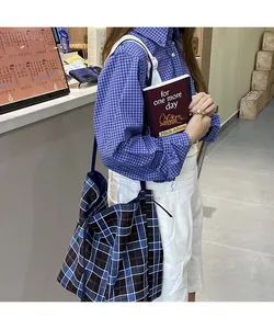 Classic British style plaid tote bag in navy and red worn with a matching casual outfit
