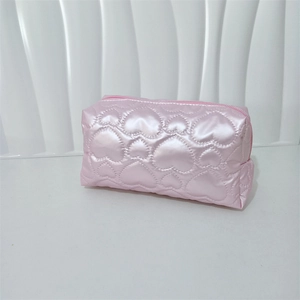 Detail view of pink heart-quilted waterproof PU makeup bag with smooth zipper closure