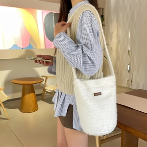 Sac seau en peluche blanche avec marquage rétro porté en bandoulière