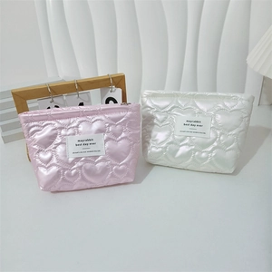 Quilted heart cosmetic bag detail with satin finish and top zipper closure