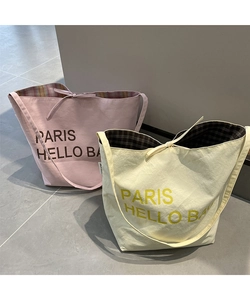 Detail of canvas tote bag showing interior checkered lining and PARIS HELLO BAG print