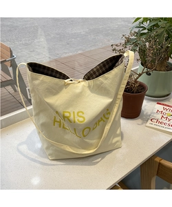 Close-up of beige tote bag showing brown checkered lining and drawstring closure