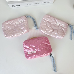 Close-up of quilted heart pattern and zip detail on these pink makeup pouch bags