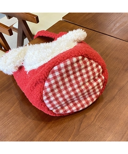 Detail der roten Lammwoll-Beuteltasche mit weißen Plüschohren und kariertem Taschenboden