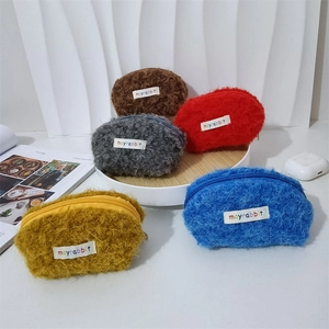 Dettaglio di cinque mini pochette colorate in peluche con cerniera e etichette